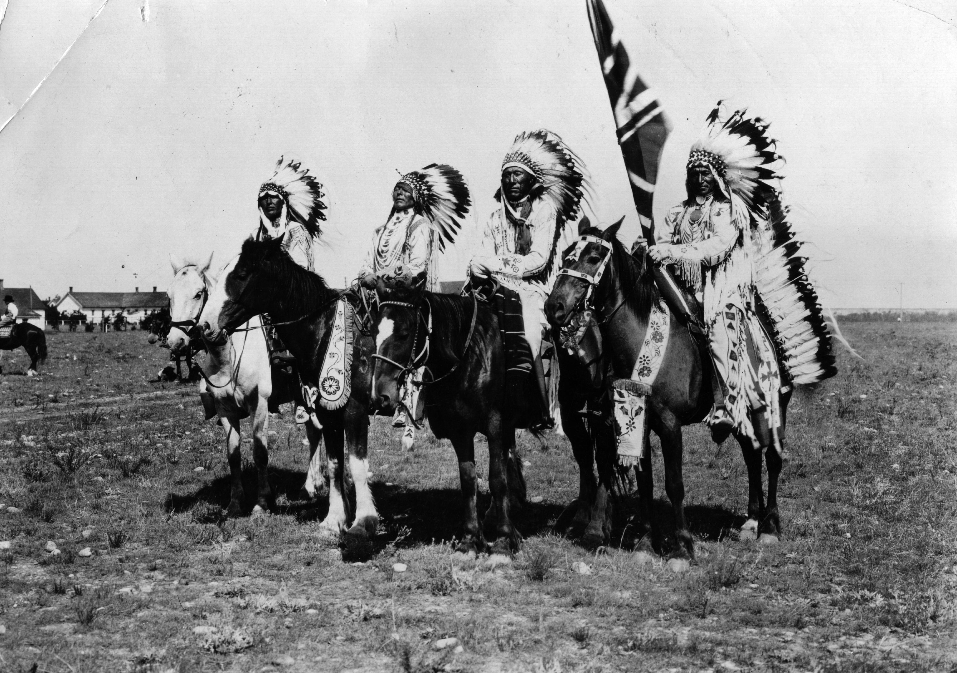 Native chiefs on horseback, wearing long, feathered headdresses. Native chiefs on horseback, wearing long, feathered headdresses.