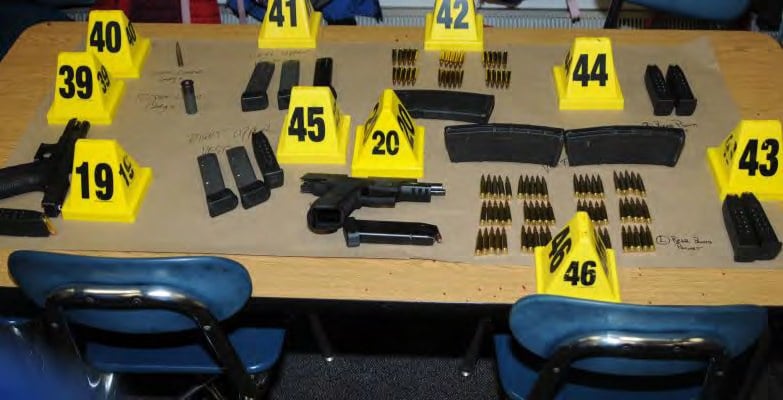 A table full of guns and ammunition A table full of guns and ammunition