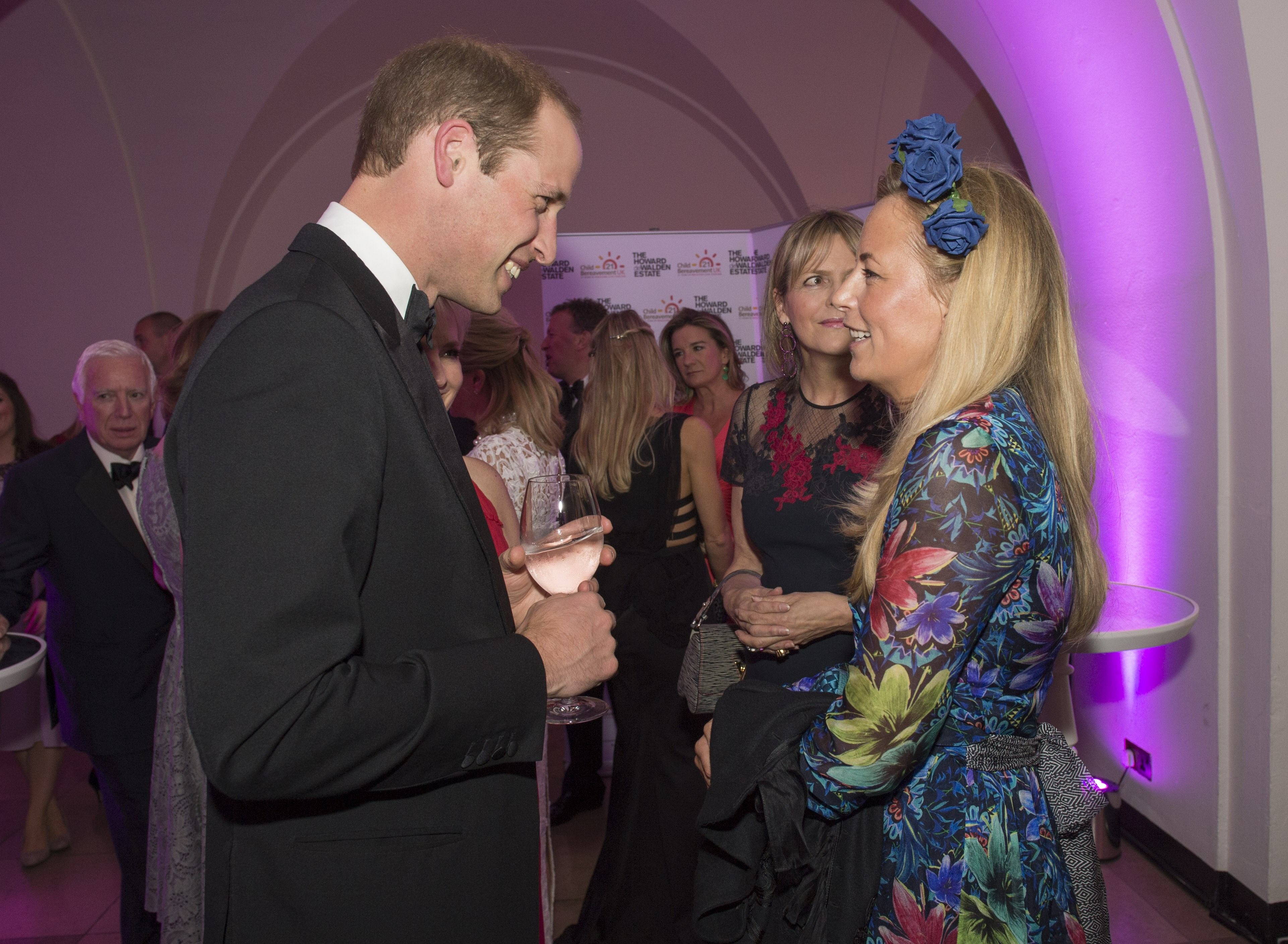 Britain's Prince William, Duke of Cambridge, (L) talks with guests Astrid Harbord during a charity dinner