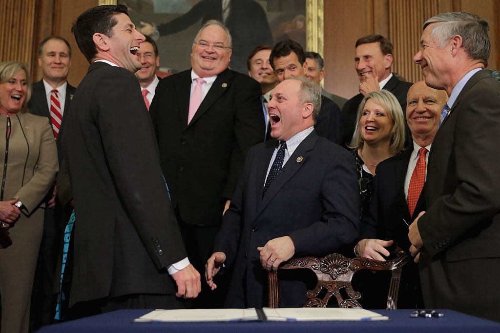 Speaker of the House Paul Ryan (R-WI) (3rd L) shares a laugh with Republican members of Congress after signing legislation to repeal the Affordable Care Act