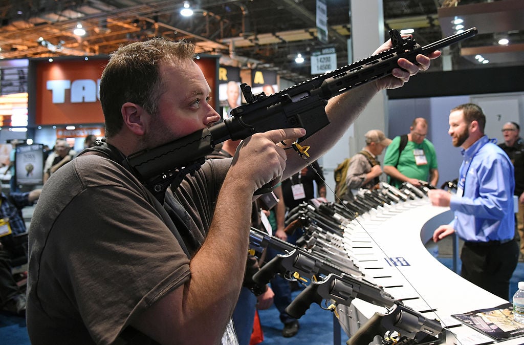 Man sighting a rifle at a gun show