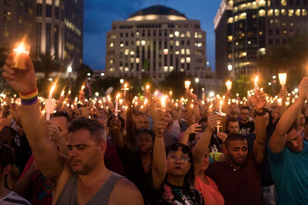 People hold candles during an evening memorial service for the victims of the Pulse Nightclub shootings, at the Dr. Phillips Center for the Performing Arts