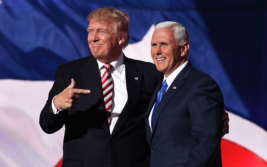 Donald Trump in a dark suit pointing at Mike Pence, also in a dark suit