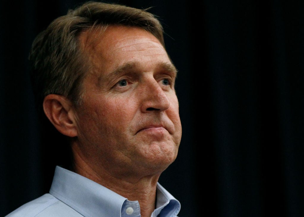 Jeff Flake tight, in a blue shirt, against a dark background