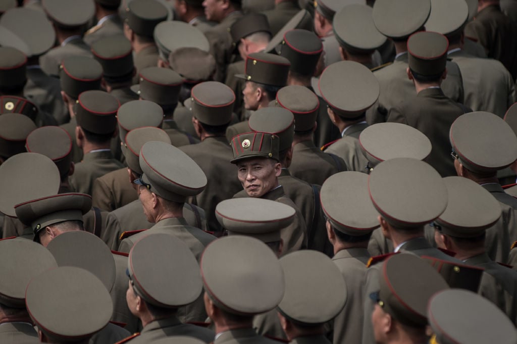 a sea of North Korean army members in gray hats from the air
