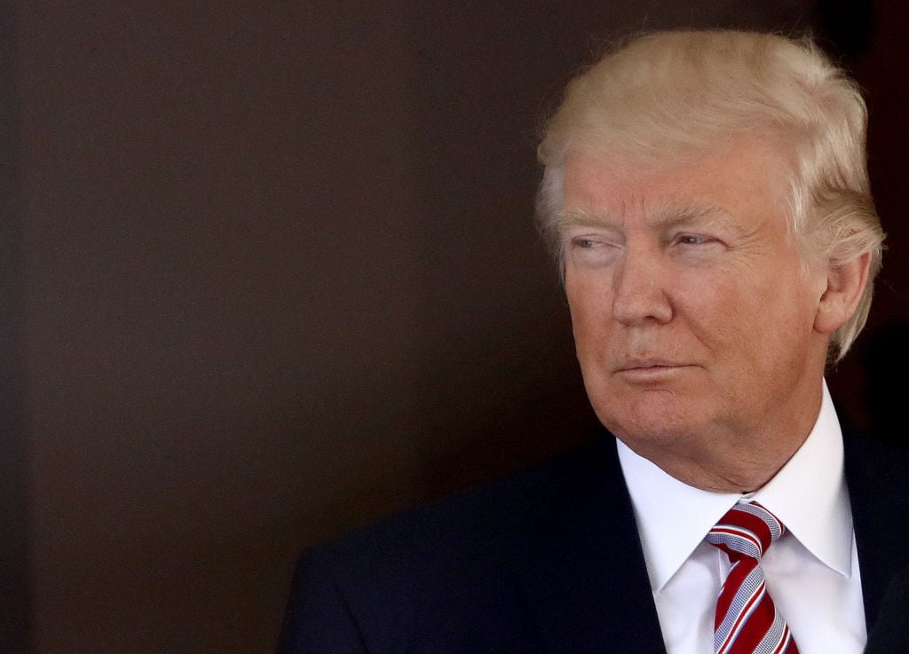 Trump face looking left on a dark background