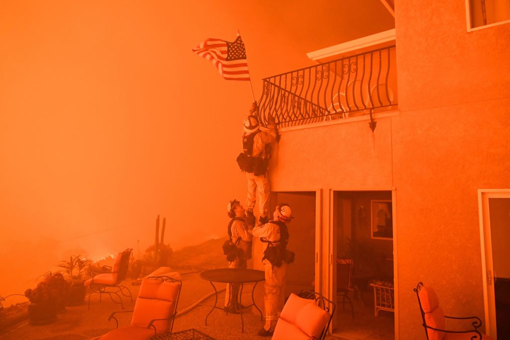 firefighters climbing up to an american flag in a home, in orange firefighters climbing up to an american flag in a home, in orange