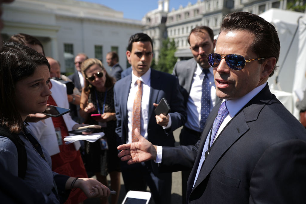 Anthony Scaramucci in sunglasses and a suit addresses members of the media