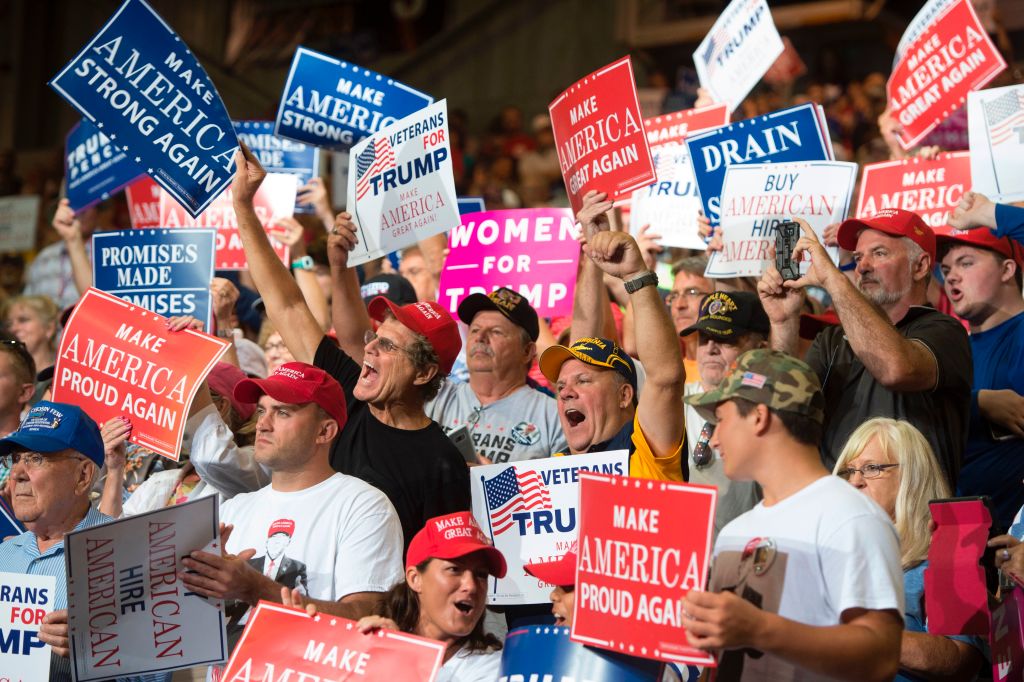 a crowd of Trump fans waving Trump signs