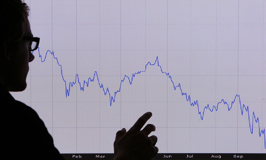 a white chart with a blue line graph and a shadow hand in front a white chart with a blue line graph and a shadow hand in front