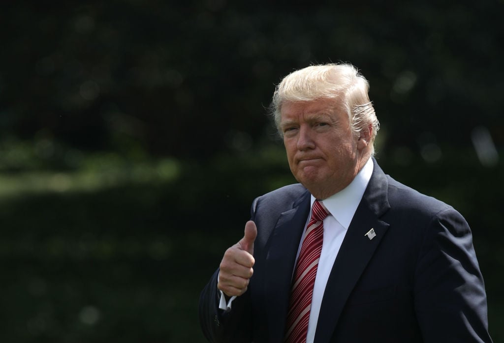Donald Trump in a dark suit and red tie giving thumbs up Donald Trump in a dark suit and red tie giving thumbs up