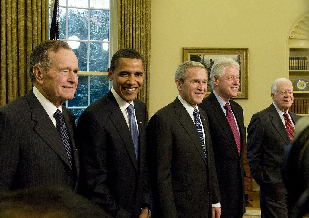 former presidents Bush, Obama, Bush, Carter, and Clinton in a row, all in dark suits