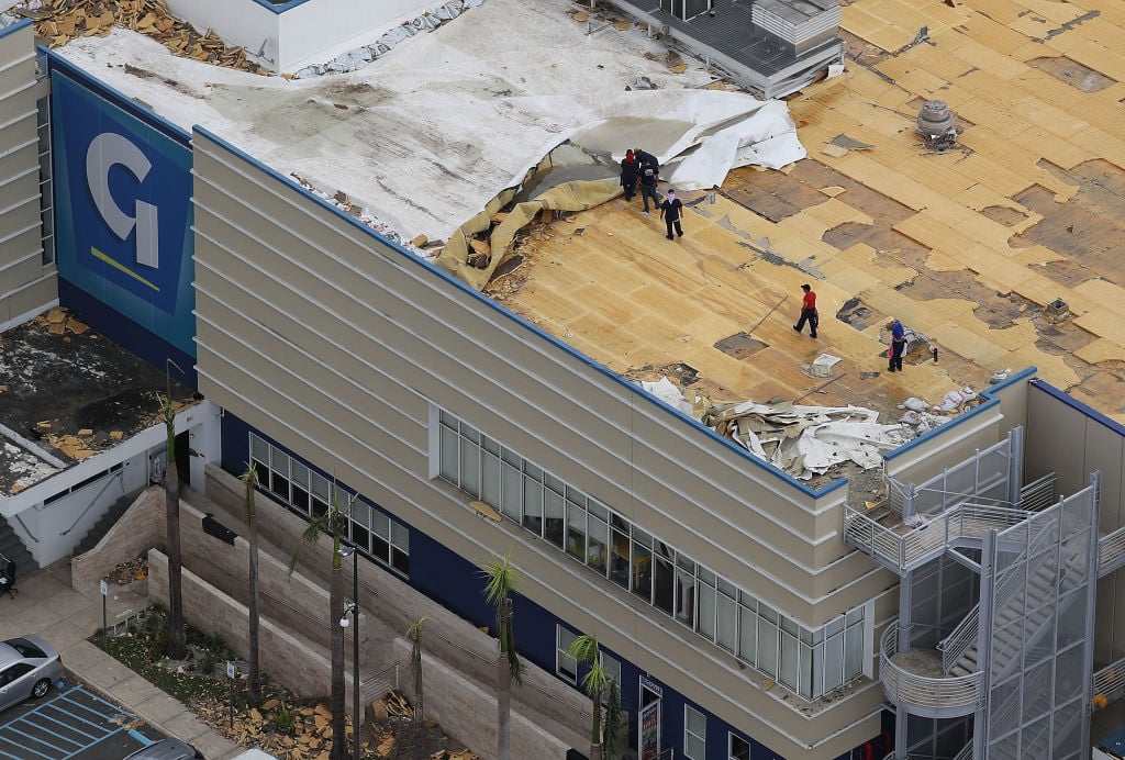Workers repair roof of a power plant after hurricane maria