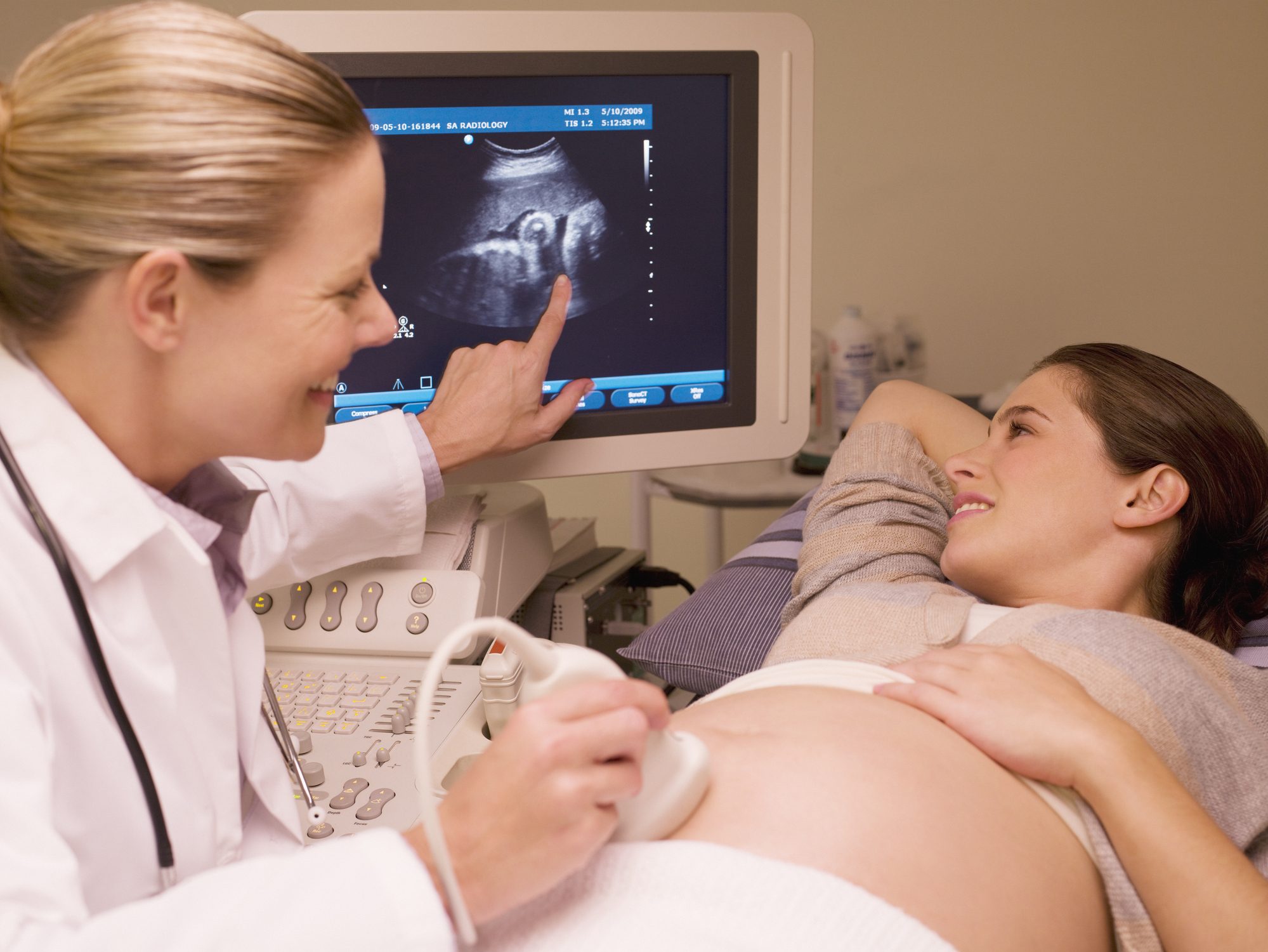 Woman looking at ultrasound results with doctor.