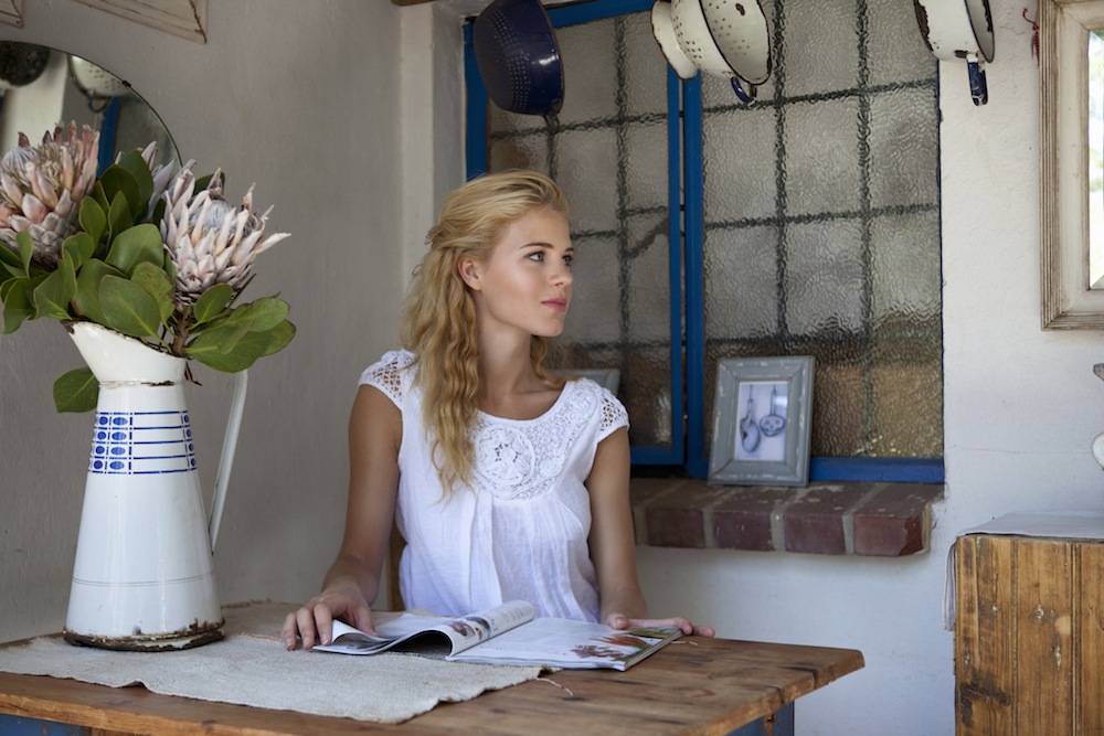 Girl reading a magazine at an antique table