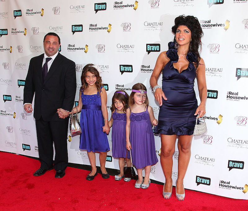Teresa and Joe Giudice standing with their three children.