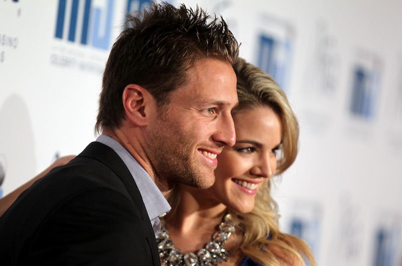 Juan Pablo Galavis and Nikki Ferrell stand close to each other as they smile at photographers.