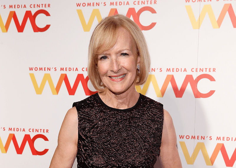 Judy Woodruff smiles and stands in a sequined gown at an event. Judy Woodruff smiles and stands in a sequined gown at an event.