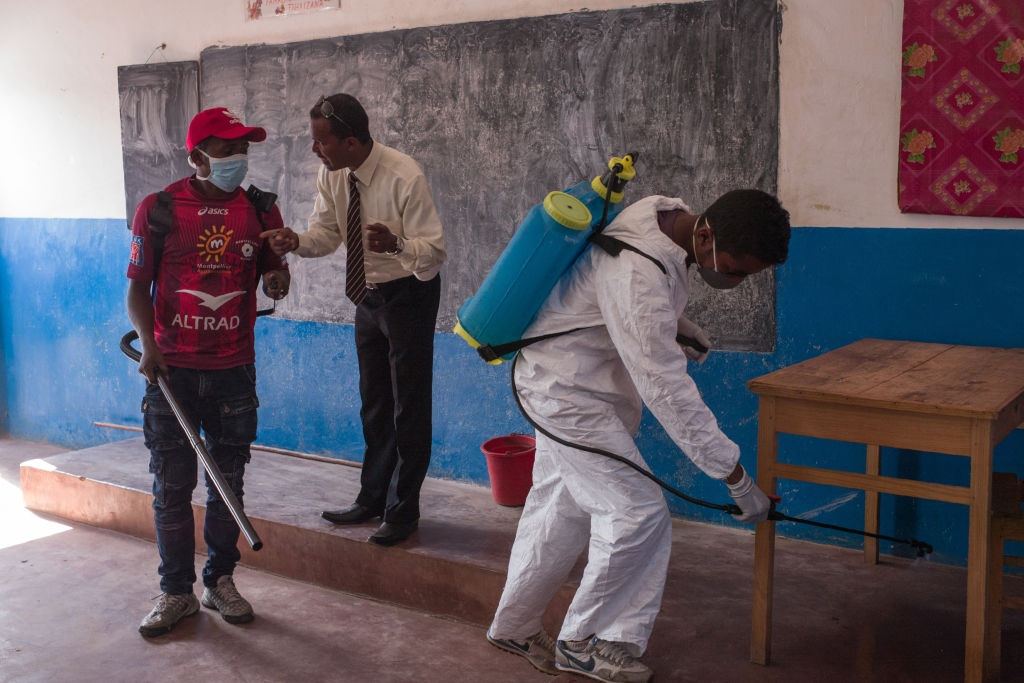 Officers spray pesticide against fleas in a Madagascar school Officers spray pesticide in a Madagascar school