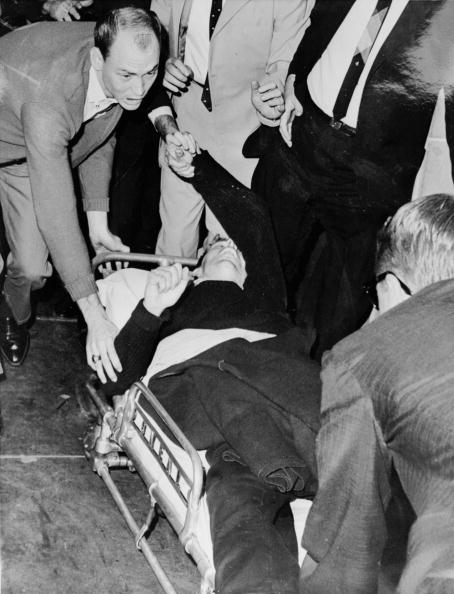 Lee Harvey Oswald is hurried into an ambulance after being shot