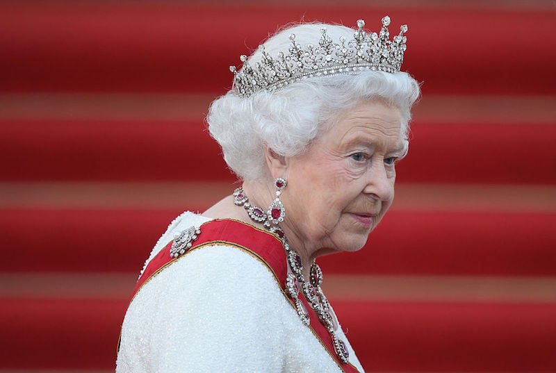 Queen Elizabeth II wearing a tiara and a red sash. 