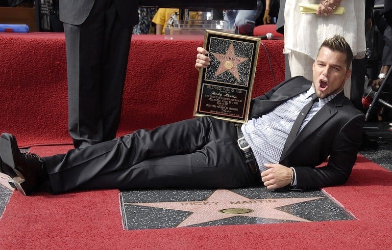 Ricky Martin posing with his star and plaque.