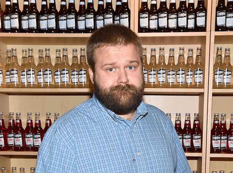 Robert Kirkman standing in front of glass bottles. Robert Kirkman standing in front of glass bottles.