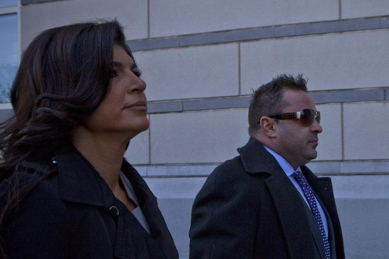 Teresa and Joe walk side by side while looking straight ahead on a sidewalk Teresa and Joe walk side by side while looking straight ahead on a sidewalk