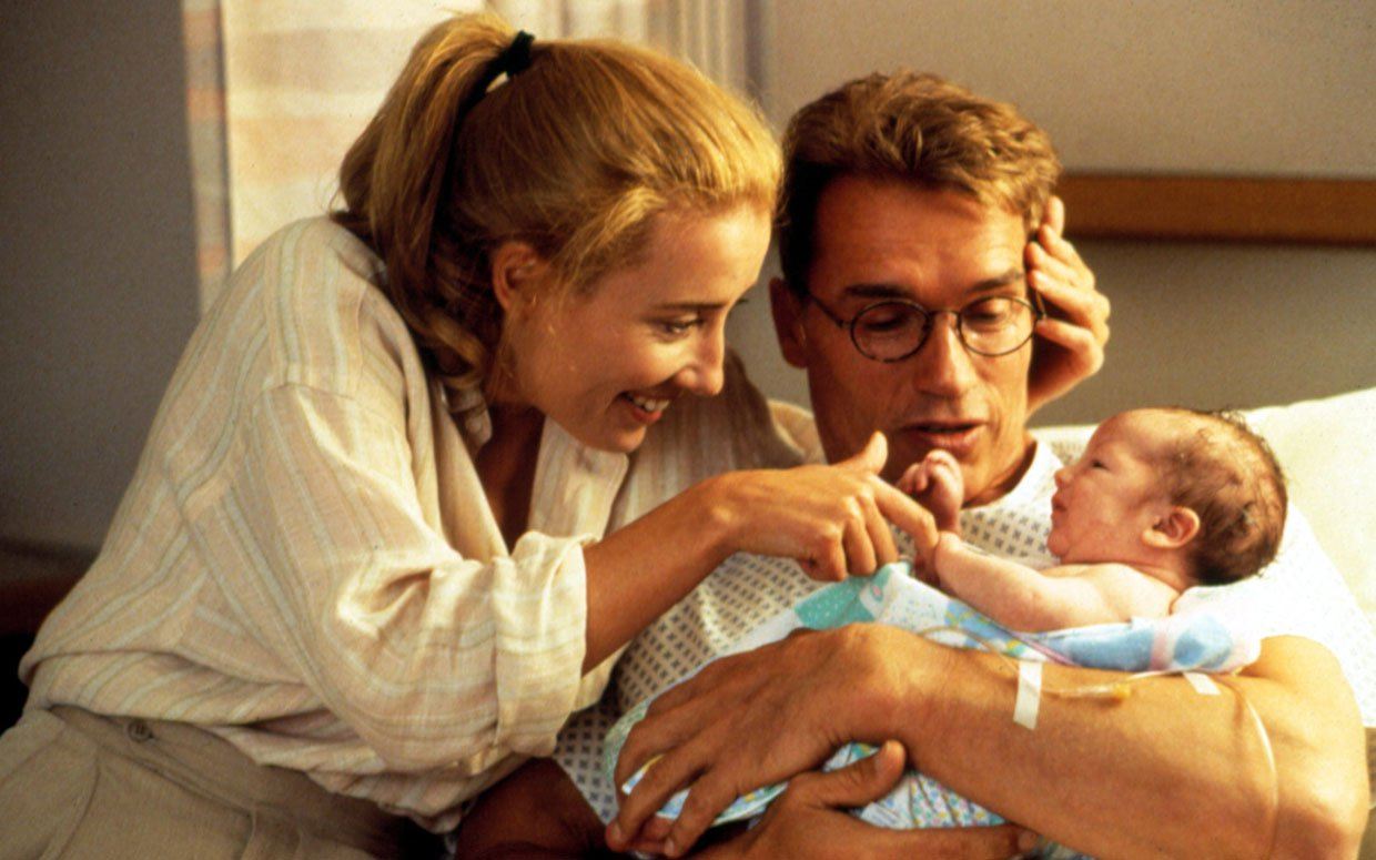 Arnold Schwarzenegger and Emma Thompson look at a baby in Junior 