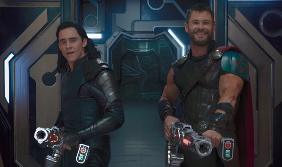 Loki and Thor holding big guns while laughing