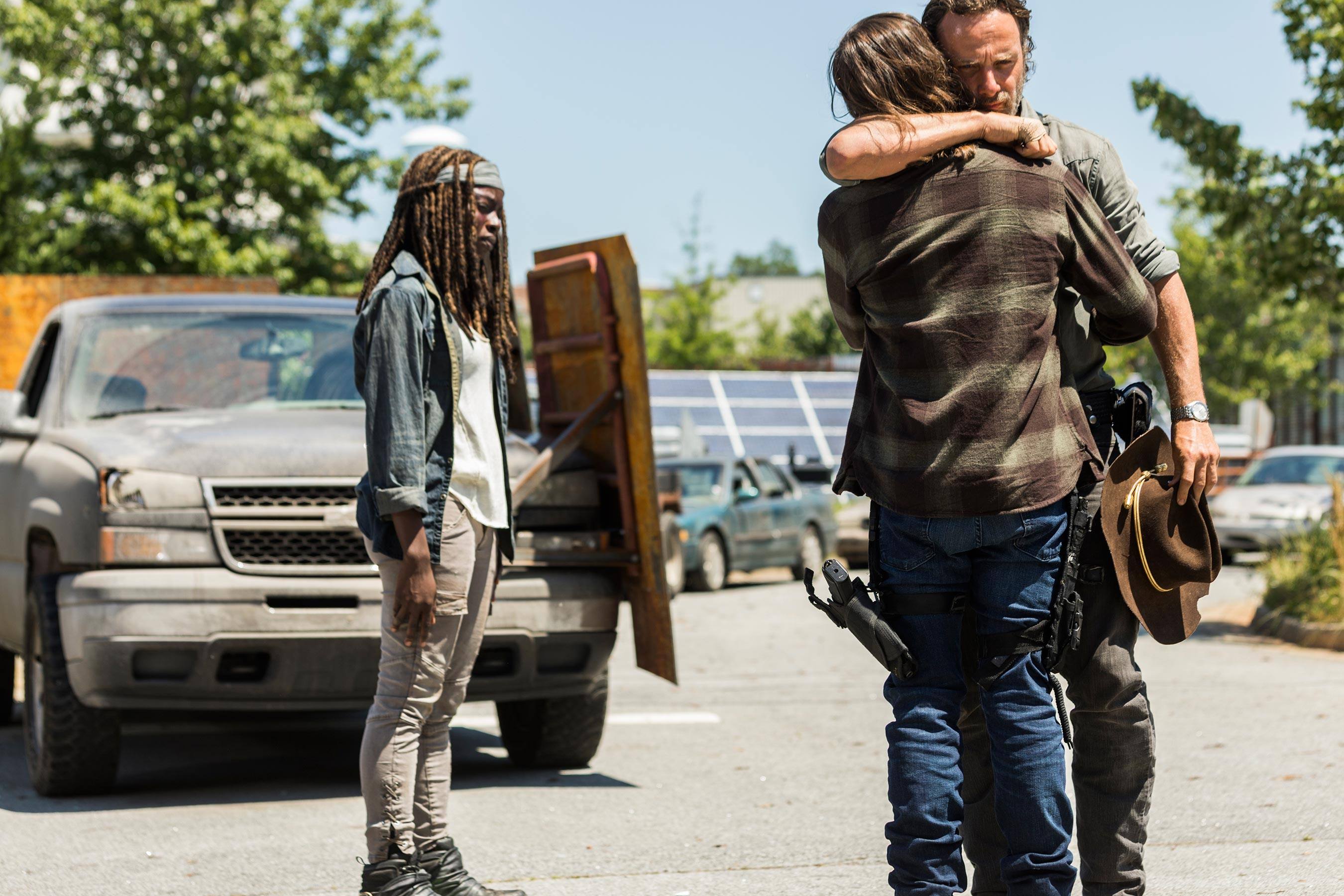 Carl and Rick embrace while Michonne stands away from them