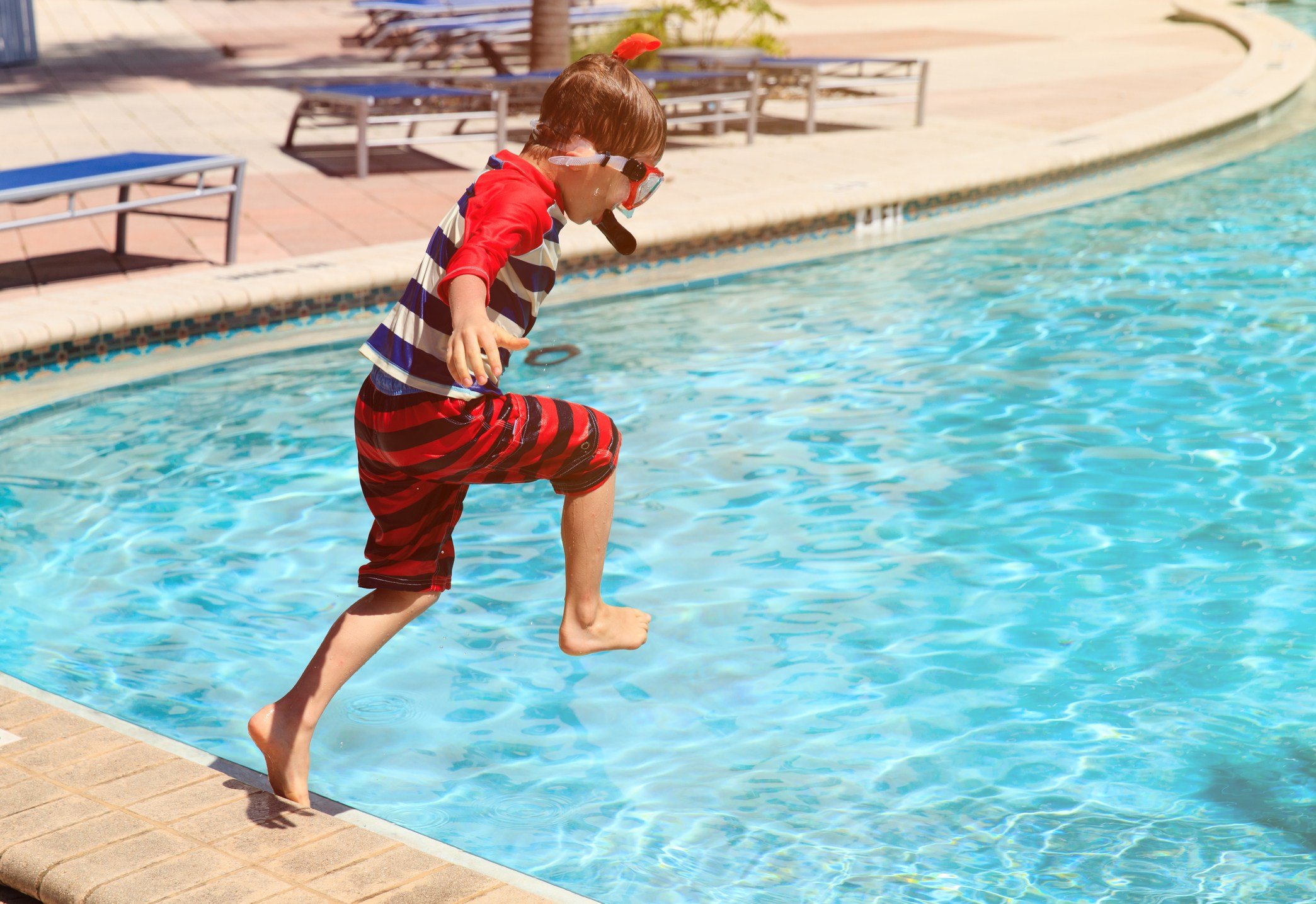 Boy jumping into the pool