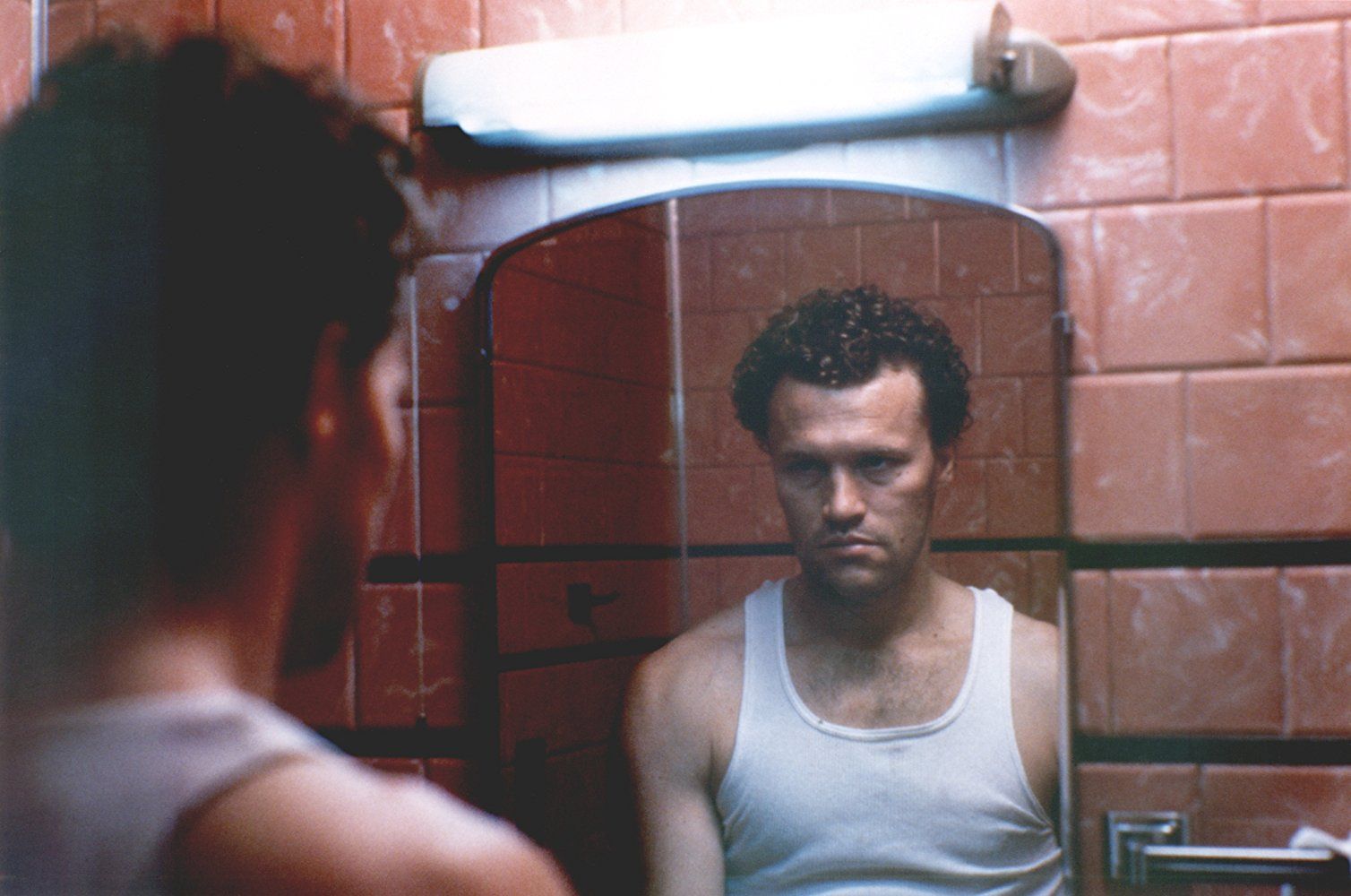 Michael Rooker in Henry: Portrait of a Serial Killer looking at himself in the mirror