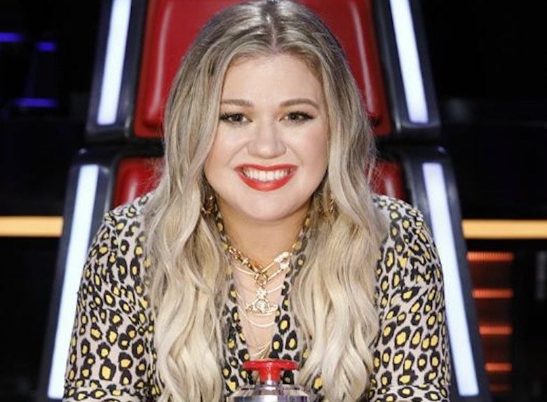 Kelly Clarkson sits on a red The Voice chair