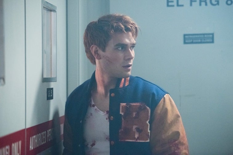 K.J. Apa as Archie Andrews wears a bloodied white tank and letterman jacket in Riverdale 
