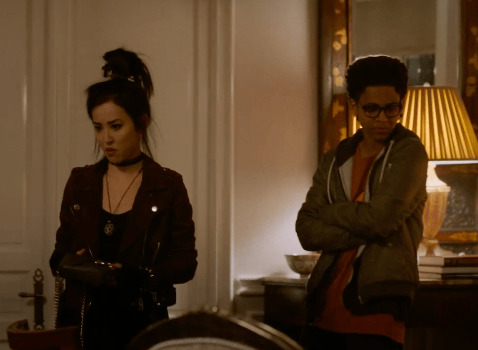 Two teens stand with their arms crossed Two teens stand with their arms crossed