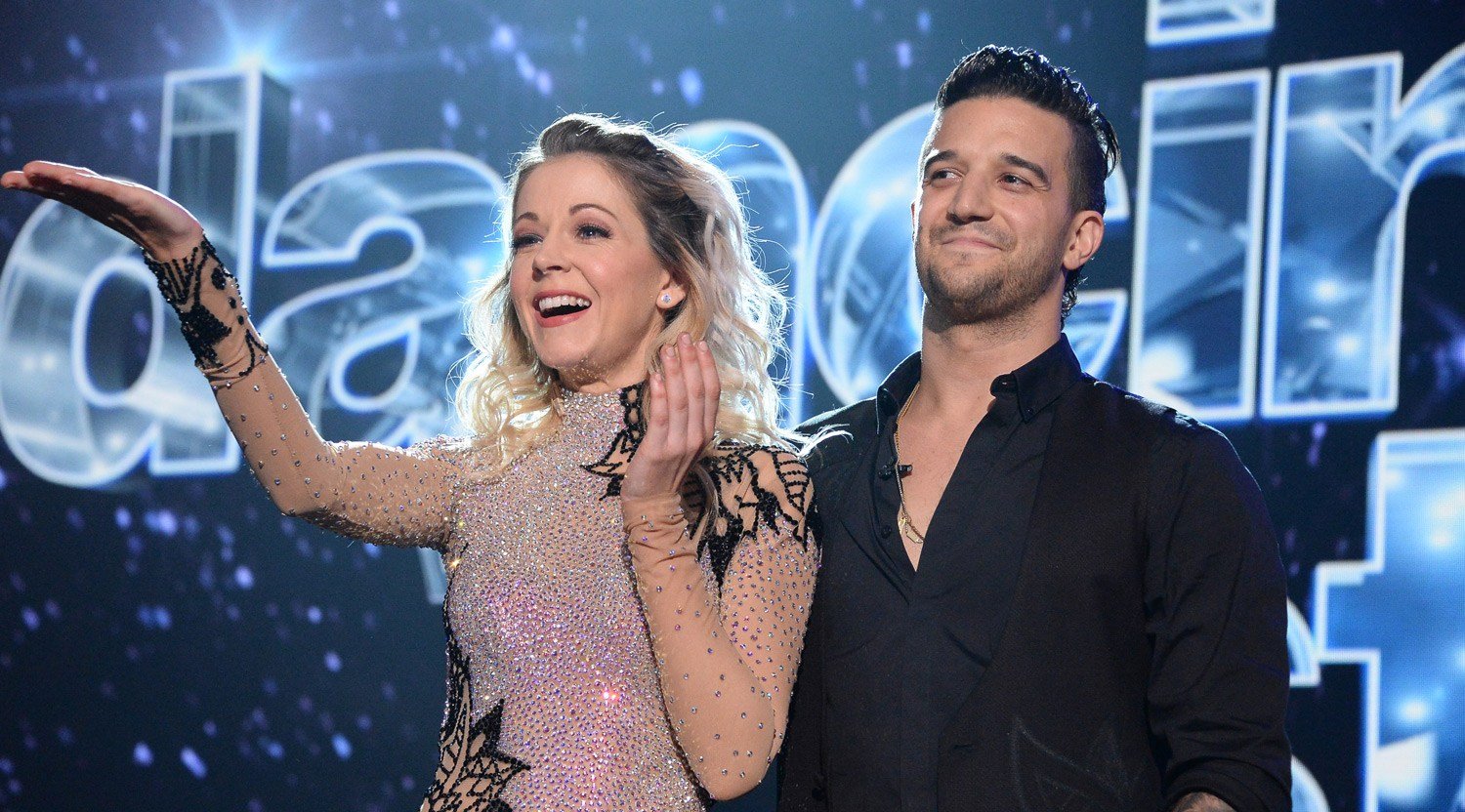 Lindsey Stirling and Mark Ballas stand next to each other on the stage