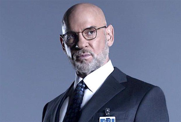 Mitch Pilegg wears a suit and glasses and looks to the side Mitch Pilegg wears a suit and glasses and looks to the side