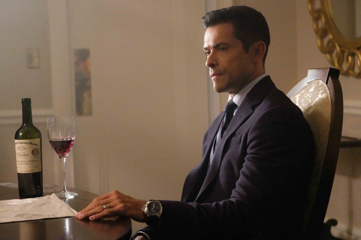 Mark Consuelos as Hiram Lodge sits in a suit at a dining room table in front of a glass of wine Mark Consuelos as Hiram Lodge sits in a suit at a dining room table in front of a glass of wine