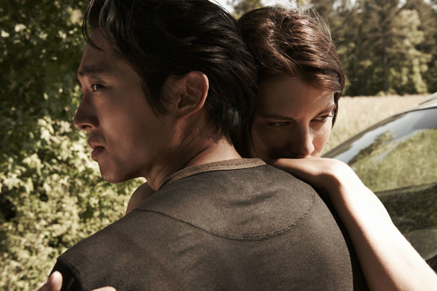 Glenn hugs Maggie while standing in front of trees