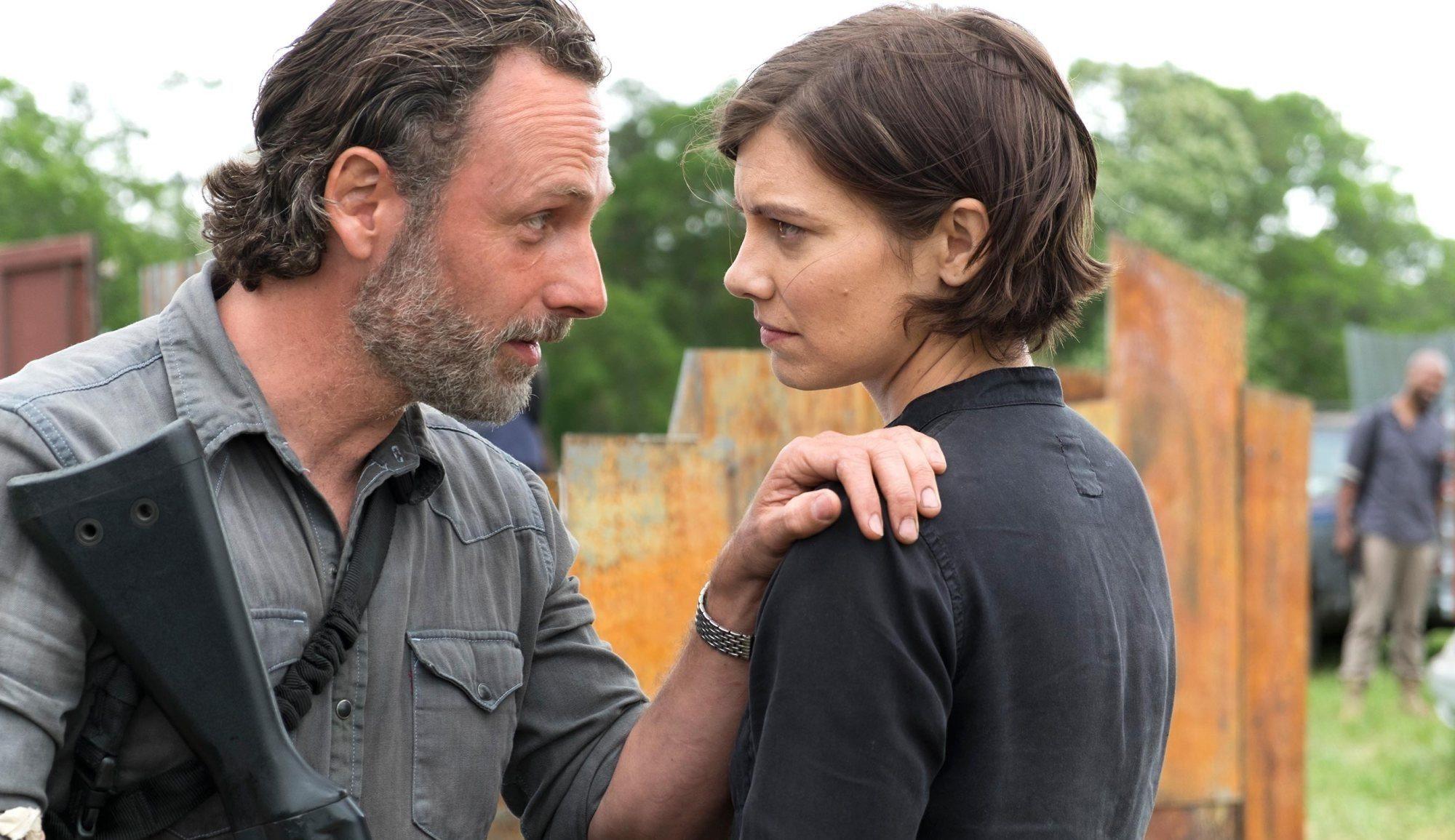 Rick puts his hand on Maggie's shoulder and holds a gun in another hand