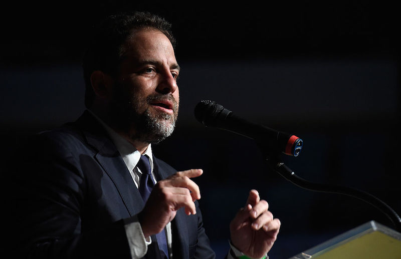 Brett Ratner speaks into a microphone while gesturing with his hands. Brett Ratner speaks into a microphone while gesturing with his hands.