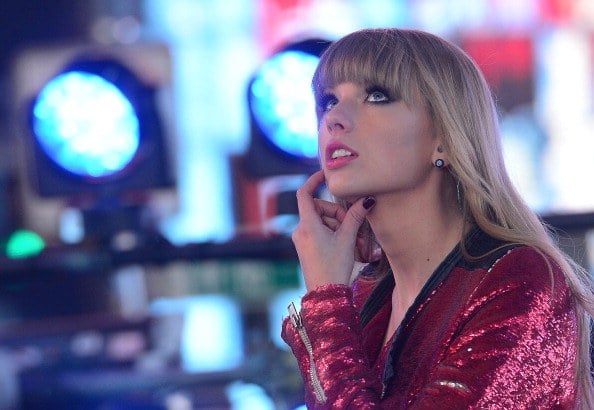 taylor swift in red with her hand on her chin taylor swift in red with her hand on her chin