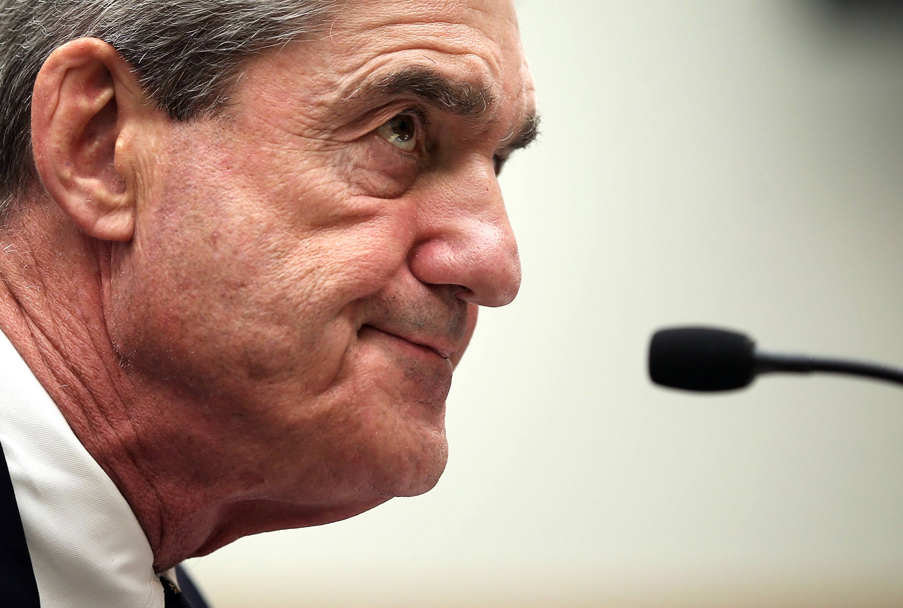 Profile of Muellers face in front of a microphone.
