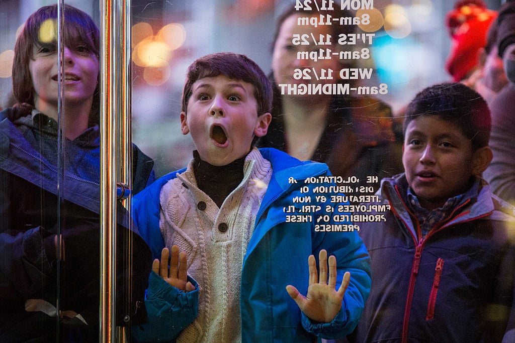 a kid presses his face against the glass at Toys R Us a kid presses his face against the glass at Toys R Us