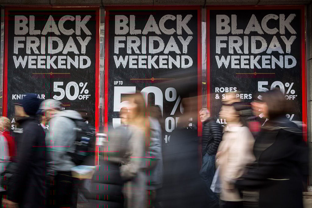 people rushing past Black Friday signs