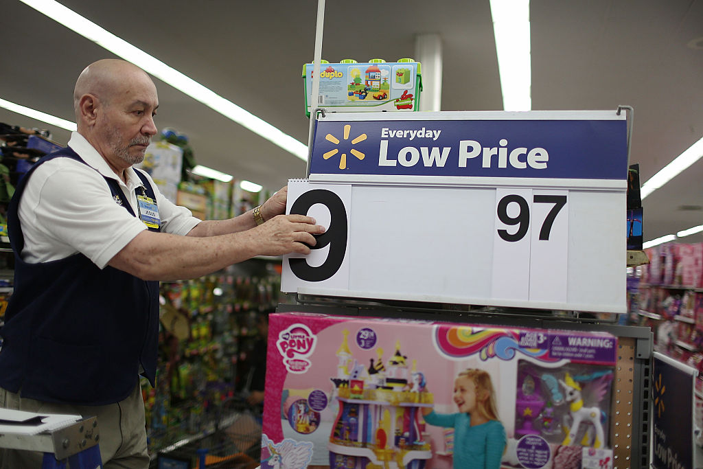 a wal-mart employee adjusts a sign ahead of Black Friday