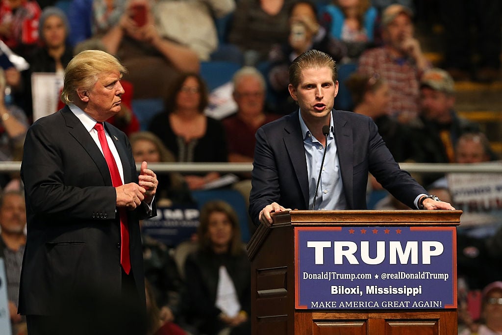 Donald Trump watches his son Eric give a speech at a podium. Donald Trump watches his son Eric give a speech at a podium.