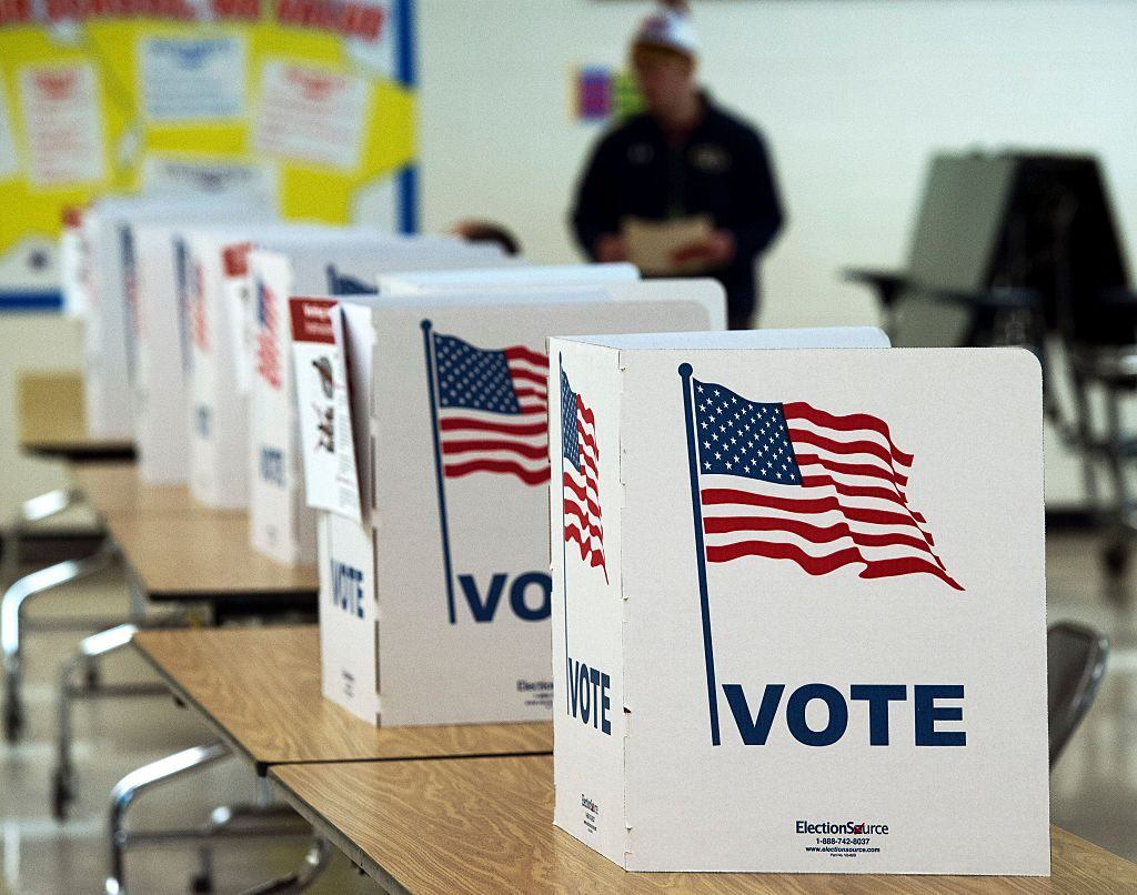 a line of white voting booths with American flags on them
