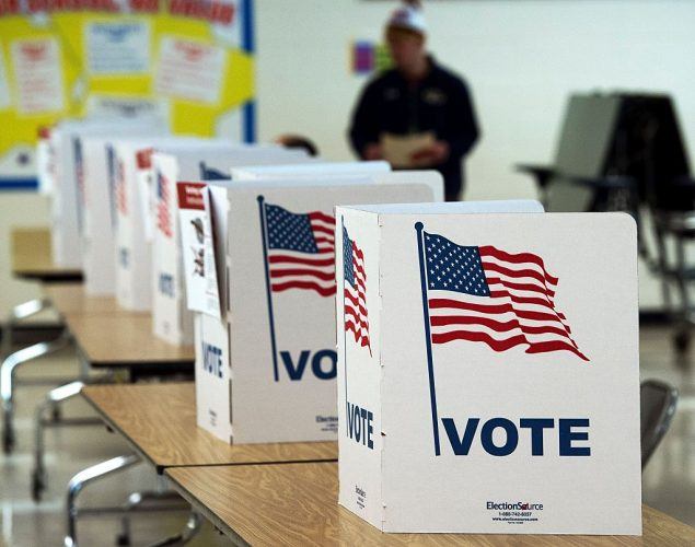 a line of white voting booths with American flags on them
